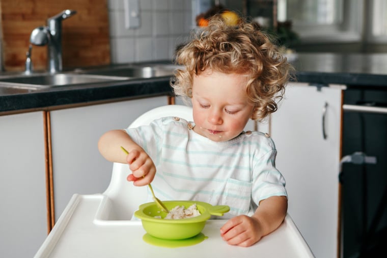 cute-baby-toddler-eating-porridge-puree-in-kitchen-2021-08-30-22-10-13-utc-2048x1365