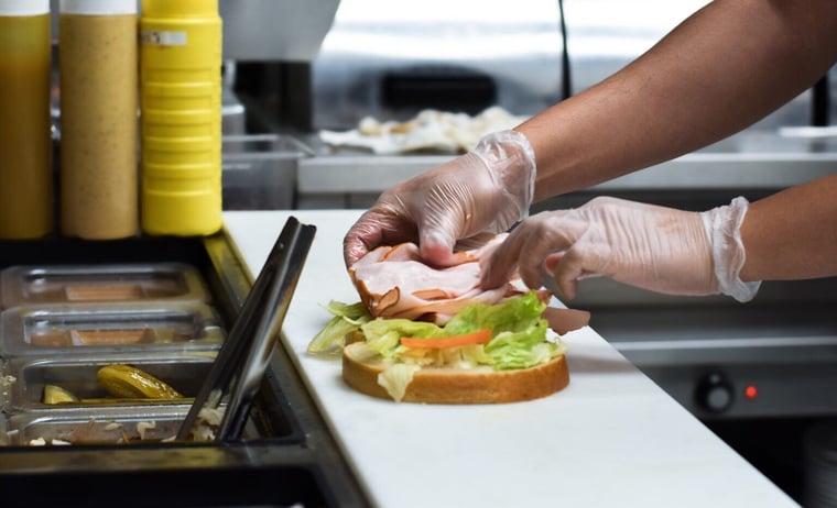 restaurant-kitchen-employee-in-gloves-placing-deli-2021-12-16-20-14-53-utc-1536x935